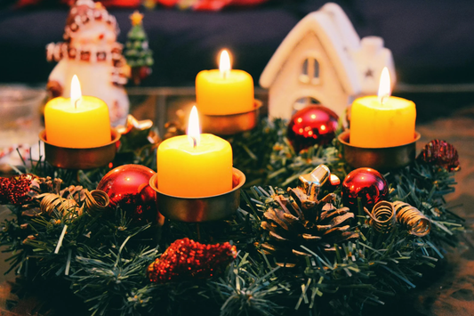 Adventskrans met brandende kaarsen en dennentakken