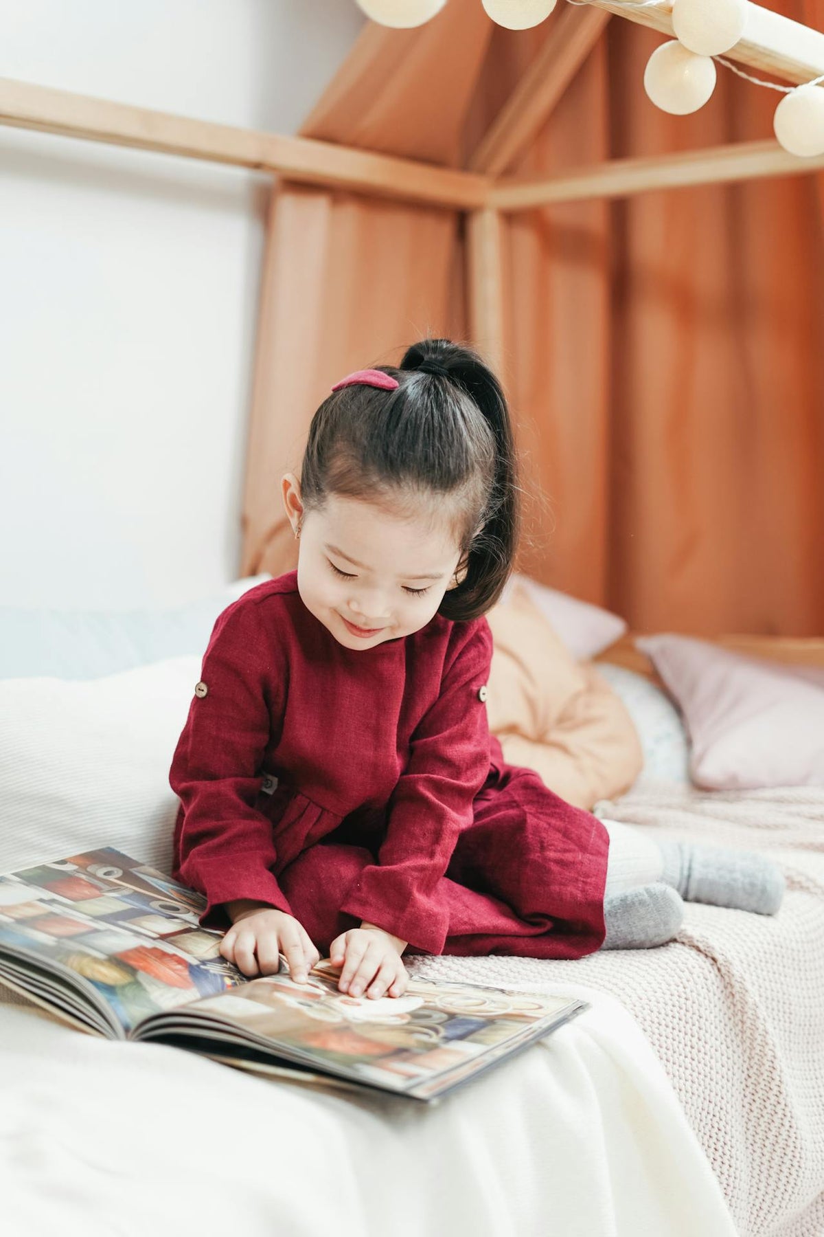 Meisje zit op bed en leest geconcentreerd