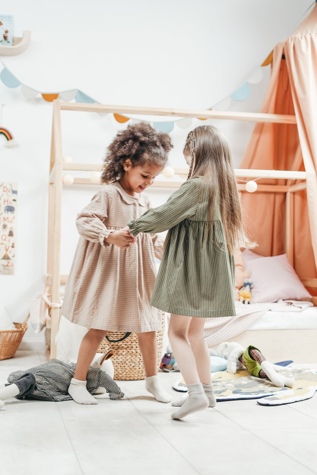 Twee meisjes in jurkjes spelen samen in een kinderkamer